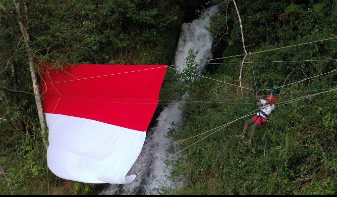 Rayakan HUT RI ke 76, Pegiat Lingkungan Warna Alam Subang Kibarkan Bendera Raksasa di Tebing Curug Cileat