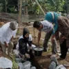 PELETAKAN BATU PERTAMA: Atlet Angkat Besi asal Kabupaten Bandung, Windy Cantika, saat meletakan sebuah batu dan adukan semen pertama pada bangunan pondasi bangunan masjid, Minggu (30/1). JABAR EKSPRES