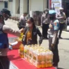 VAKSINASI: Petugas kepolisian memberikan minyak goreng kemasan kepada warga yang sudah mengikuti vaksinasi Covid-19 di Mapolsek Lembang, Senin (14/3). EKO SETIONO/PASUNDAN EKSPRES