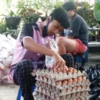 BSNT: Petugas E Warong tengah melayani keluarga penerima manfaat BSNT yang membeli telor. EKO SETIONO/PASUNDAN EKSPRES