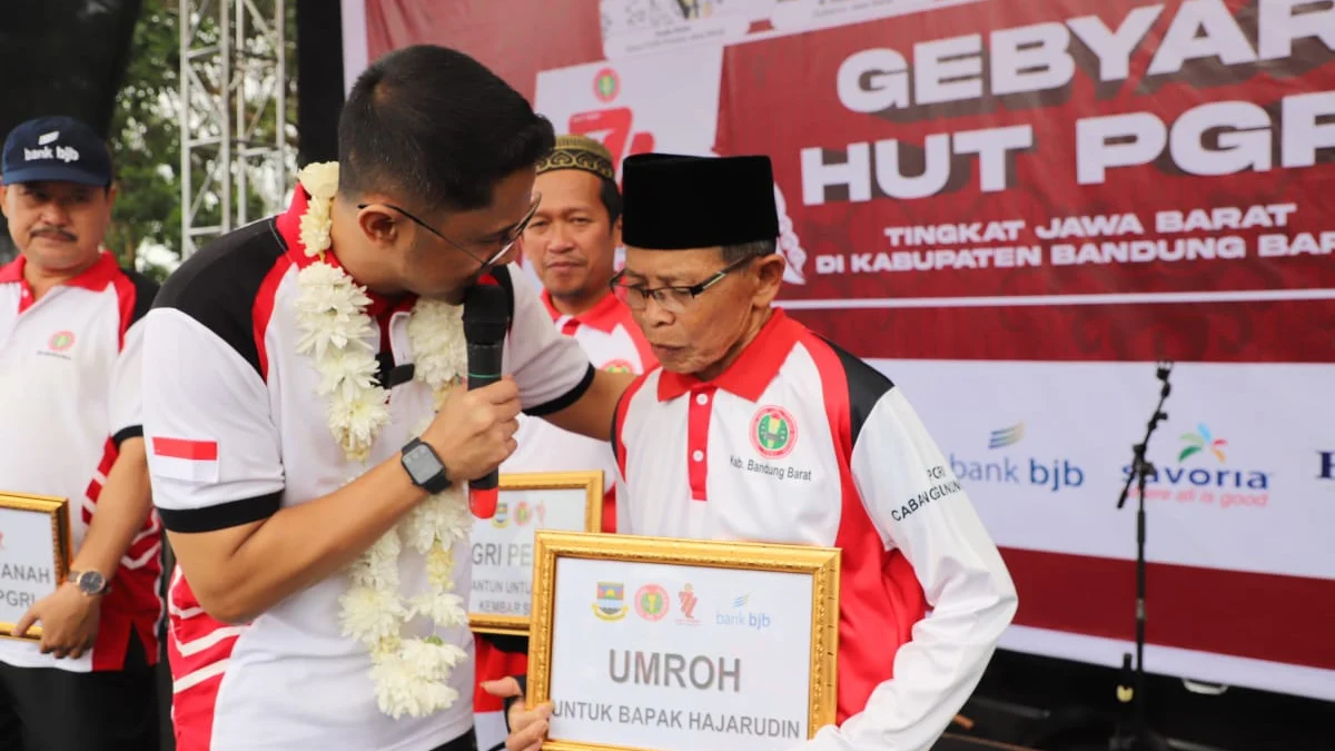 KADO SPESIAL: Guru honorer Hadjarudin Sufianan (75) mendapatkan kado spesial umroh gratis yang diberikan Bupati Bandung Barat Hengky Kurniawan pada Peringatan Hari Guru Nasional di Lapangan Plaza Pemkab Bandung Barat, Sabtu (26/11).